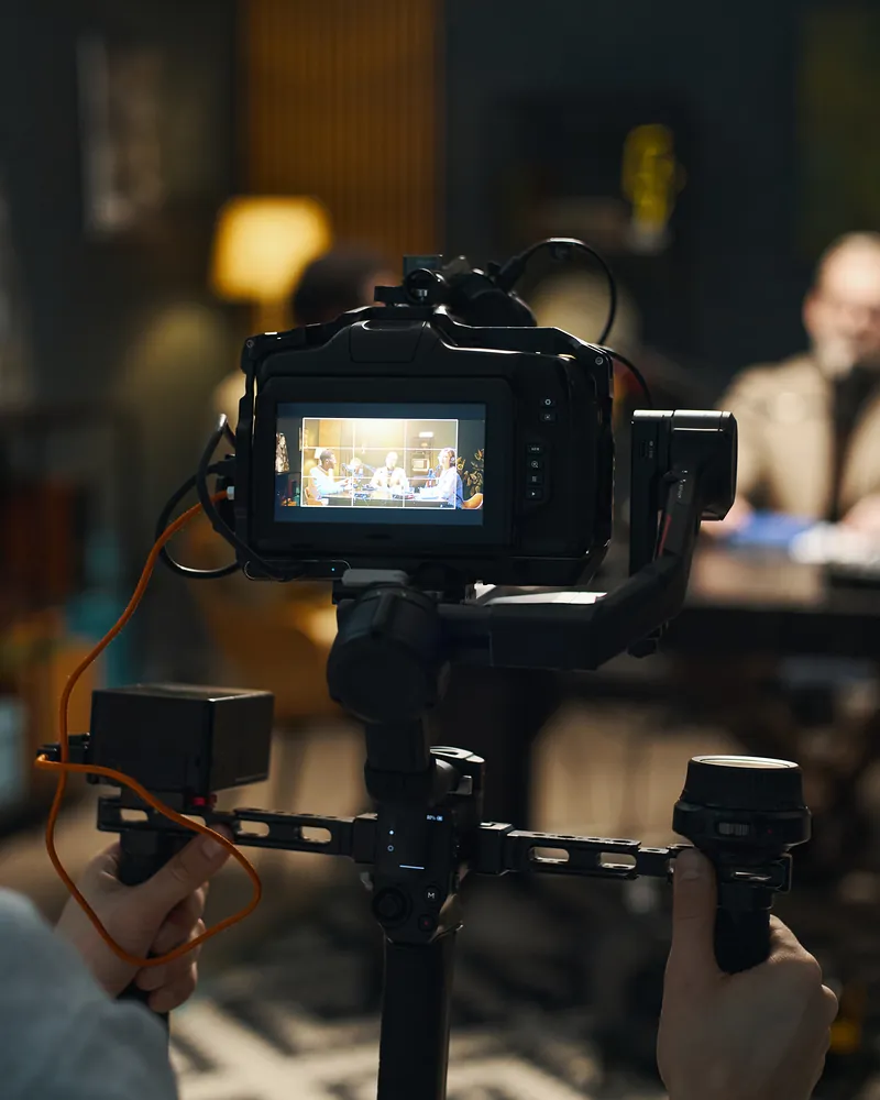 A camera operator filming a panel discussion around a table