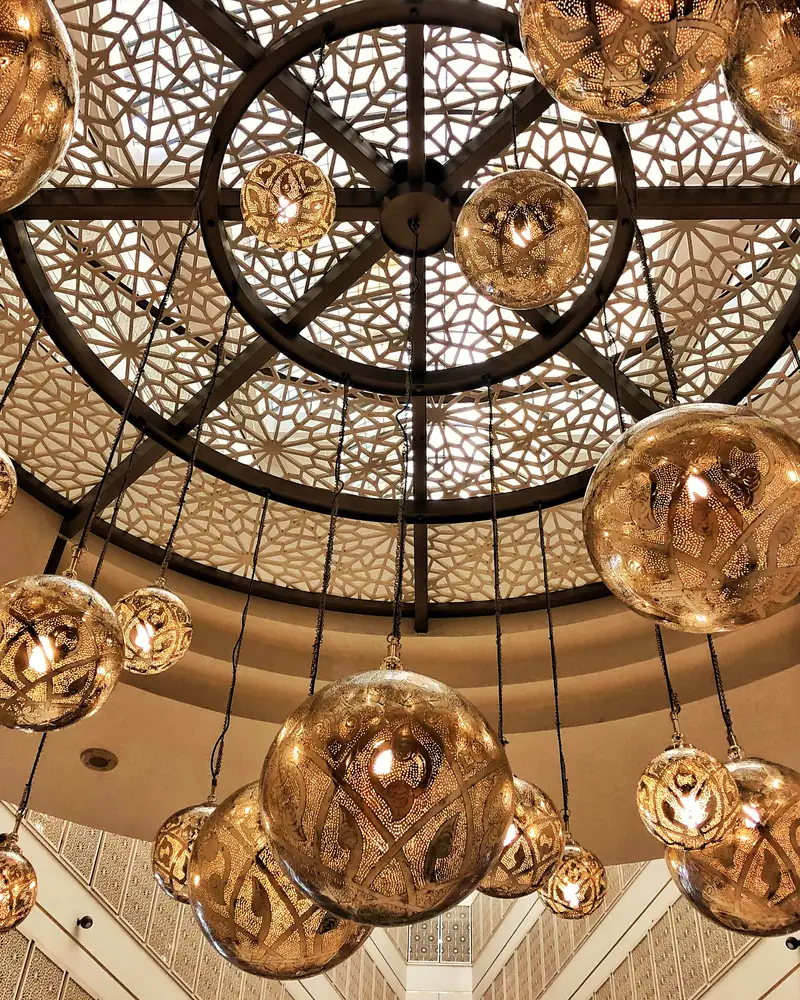 Brass lanterns hanging beneath a carved lattice dome