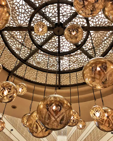 Pierced brass lanterns hanging under a carved dome
