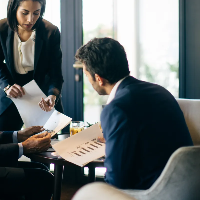 Colleagues meeting over papers at a table in a hotel restaurant