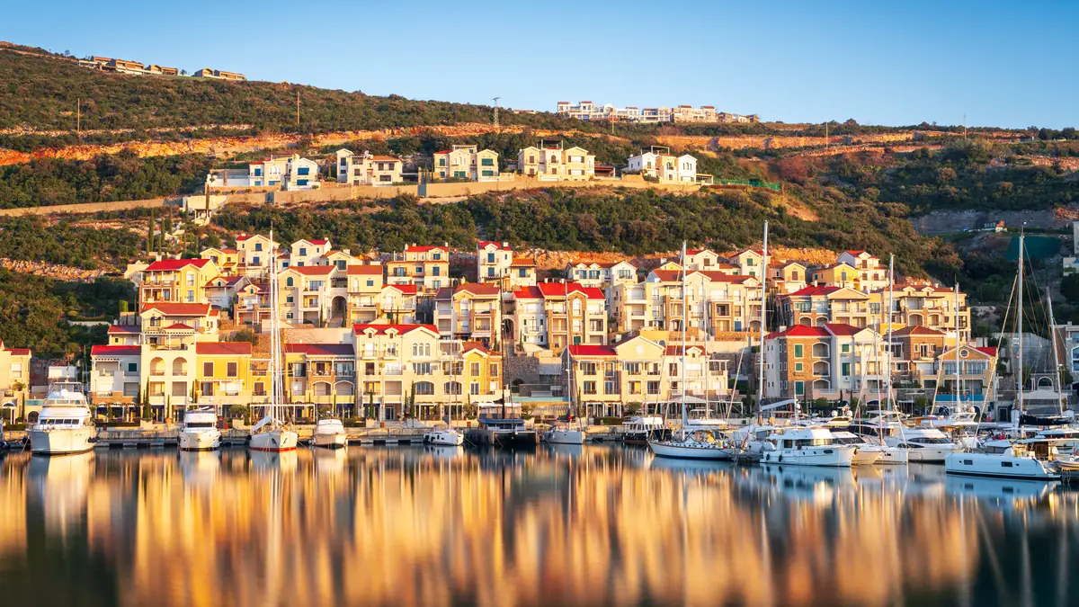 Harbour village of terraced houses above a marina at golden hour
